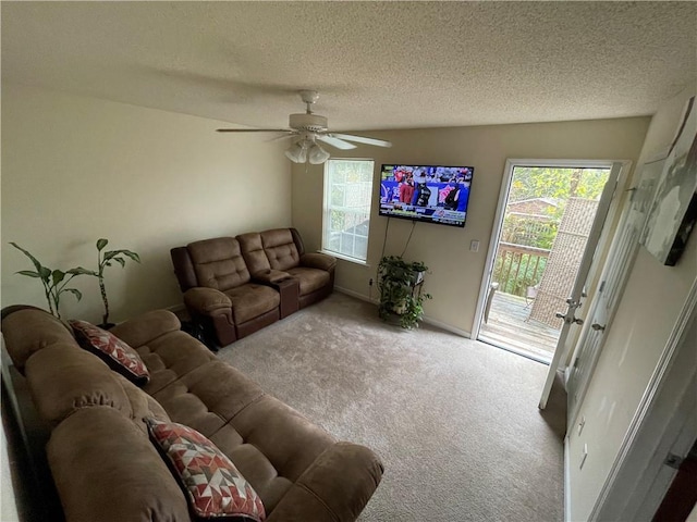 living room with a textured ceiling, light colored carpet, and ceiling fan