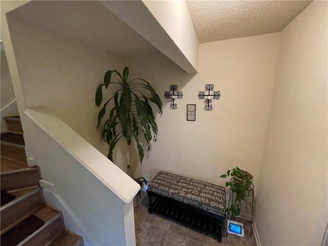 stairway with a textured ceiling