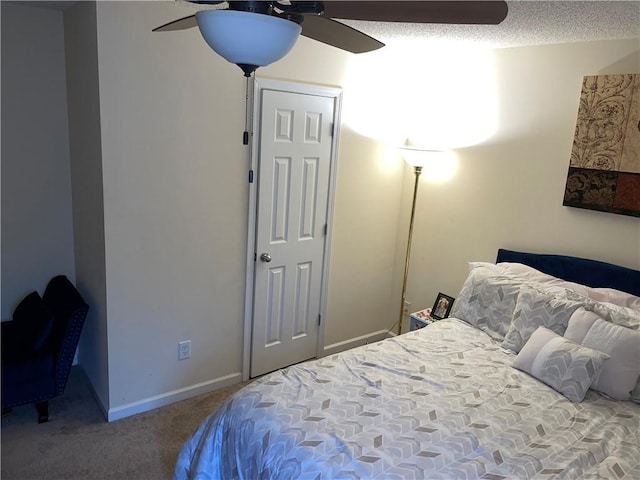 bedroom featuring ceiling fan, a textured ceiling, and carpet flooring