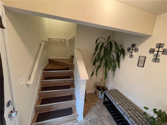 stairway with a textured ceiling