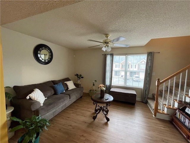 living room with a textured ceiling, hardwood / wood-style flooring, and ceiling fan