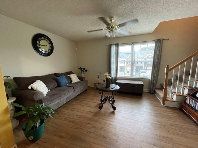 living room with wood-type flooring, a textured ceiling, and ceiling fan