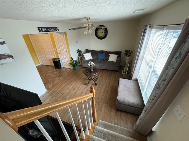 living room featuring wood-type flooring, vaulted ceiling, and a textured ceiling