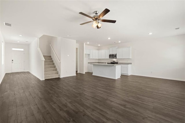 unfurnished living room featuring dark hardwood / wood-style floors and ceiling fan