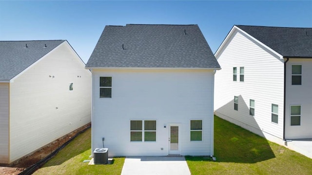 back of house featuring central AC unit and a lawn