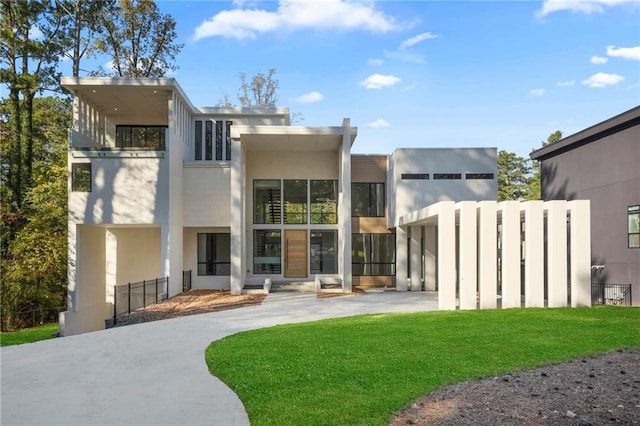 back of house featuring a lawn and a balcony