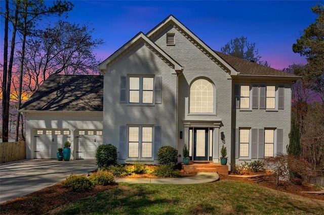 view of front facade featuring brick siding, driveway, a garage, and fence