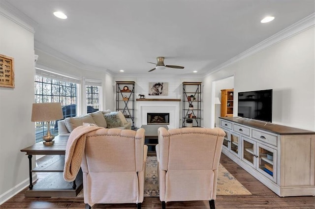 living room with dark wood-type flooring, crown molding, and a ceiling fan