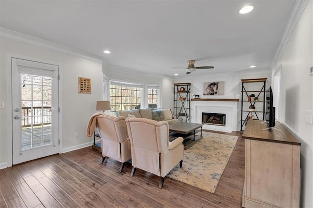 living room featuring crown molding, plenty of natural light, wood finished floors, and ceiling fan