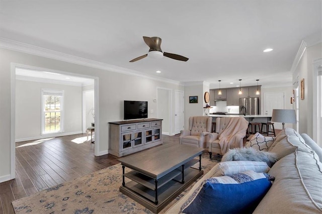 living room featuring baseboards, a ceiling fan, ornamental molding, and dark wood-style flooring