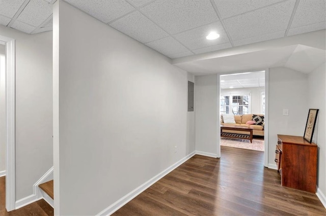 hall with dark wood finished floors, stairway, a paneled ceiling, and baseboards