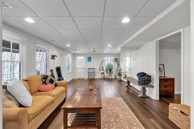 living room with recessed lighting, baseboards, dark wood-type flooring, and a paneled ceiling