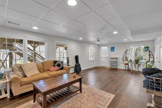 living area featuring wood finished floors, visible vents, baseboards, recessed lighting, and a drop ceiling