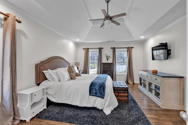 bedroom with a raised ceiling, recessed lighting, dark wood-style floors, and ornamental molding