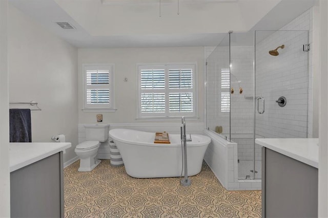 full bathroom featuring visible vents, a shower stall, a freestanding tub, tile patterned floors, and vanity