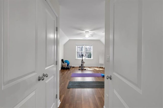 exercise room featuring ceiling fan, lofted ceiling, and hardwood / wood-style floors