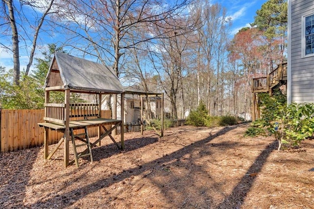 view of yard featuring stairway, a wooden deck, and fence