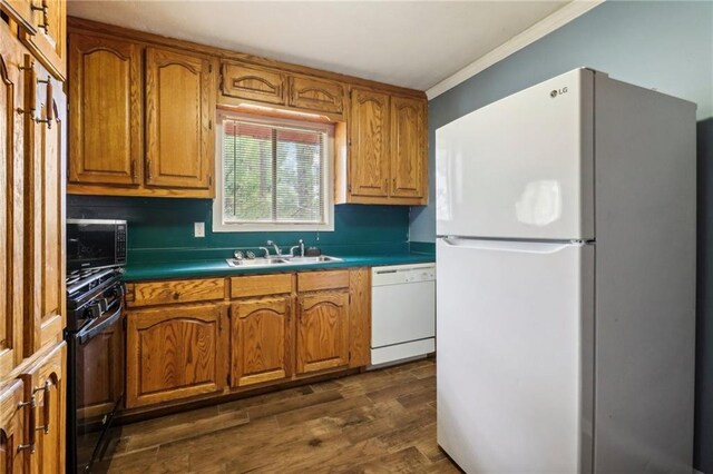 kitchen featuring dark hardwood / wood-style flooring, white appliances, crown molding, and sink