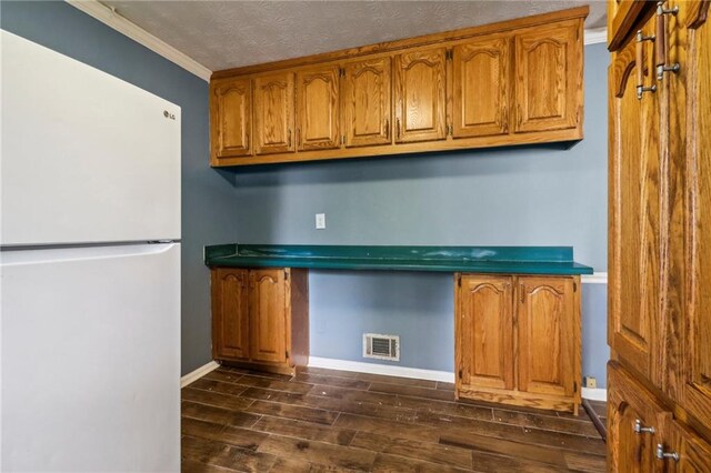 kitchen with ornamental molding, dark hardwood / wood-style flooring, and white refrigerator