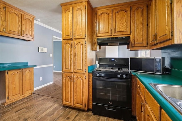 kitchen featuring ornamental molding, black gas stove, hardwood / wood-style flooring, and sink