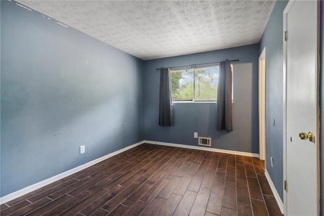 unfurnished room featuring a textured ceiling and dark hardwood / wood-style flooring