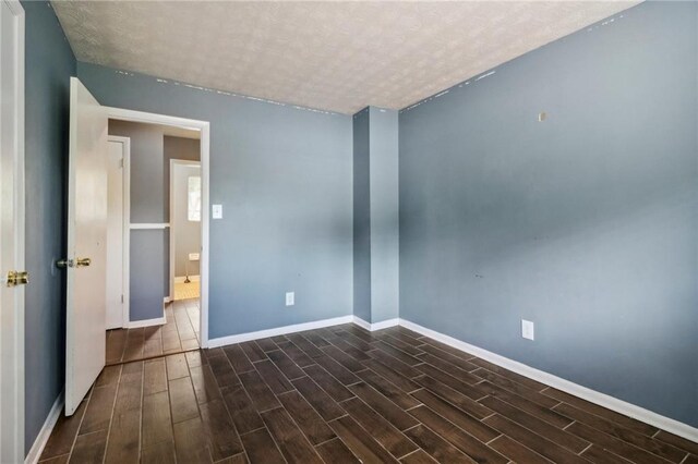 spare room with dark wood-type flooring