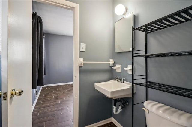 bathroom with wood-type flooring, sink, and toilet