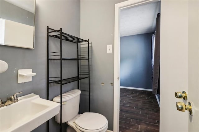 bathroom featuring toilet, hardwood / wood-style floors, and sink