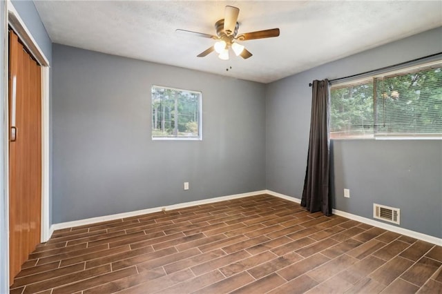 empty room featuring ceiling fan and dark hardwood / wood-style flooring