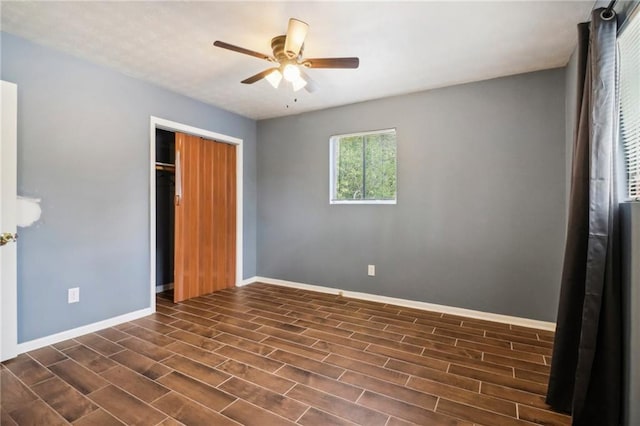 unfurnished bedroom featuring ceiling fan, a closet, and dark hardwood / wood-style floors