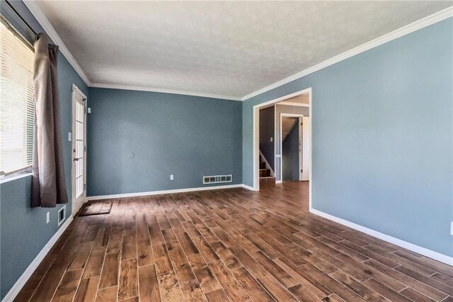 empty room featuring ornamental molding and dark hardwood / wood-style flooring