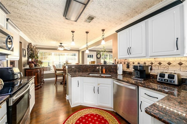 7282 Litany Ct, Flowery Branch, GA 30542 - kitchen with appliances with stainless steel finishes, a peninsula, ornamental molding, dark wood-type flooring, and a sink