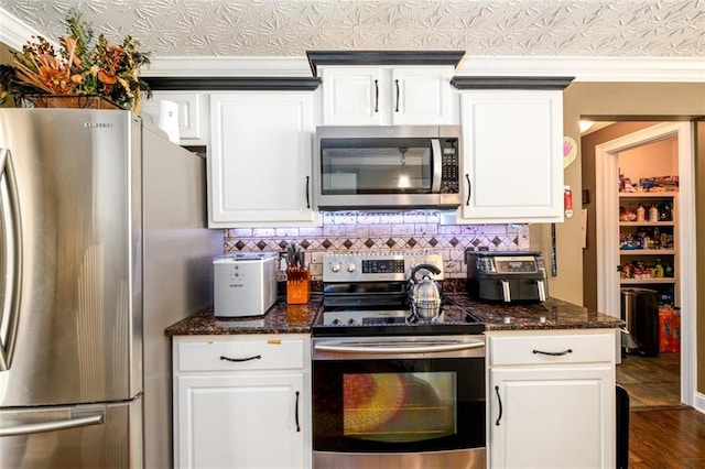 7282 Litany Ct, Flowery Branch, GA 30542 - kitchen featuring appliances with stainless steel finishes, white cabinets, tasteful backsplash, and dark stone counters