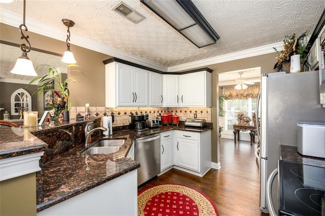 7282 Litany Ct, Flowery Branch, GA 30542 - kitchen with stainless steel dishwasher, white cabinetry, a sink, dark wood-type flooring, and pendant lighting