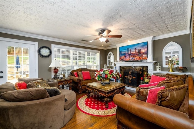 7282 Litany Ct, Flowery Branch, GA 30542 - living area featuring wood finished floors, ceiling fan, ornamental molding, and a high end fireplace