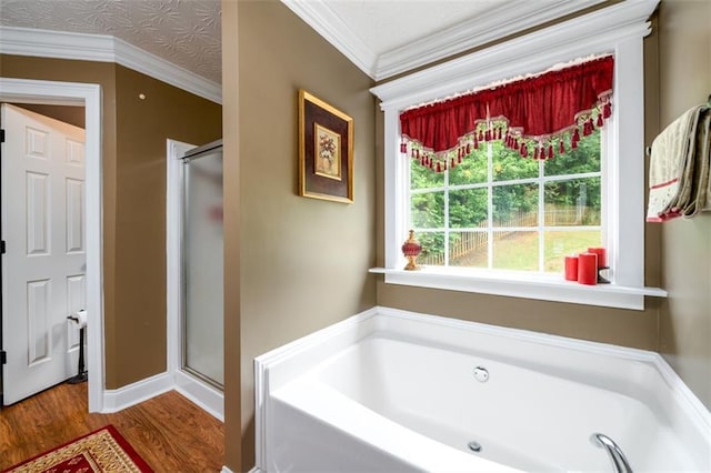 7282 Litany Ct, Flowery Branch, GA 30542 - full bath with wood finished floors, a garden tub, a stall shower, crown molding, and baseboards