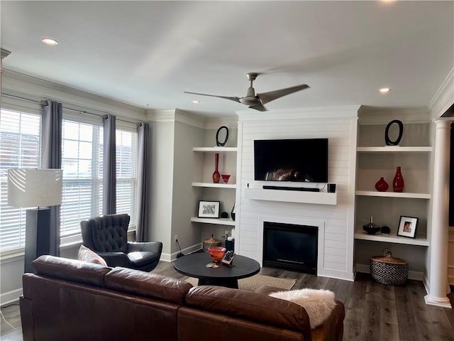 living room with plenty of natural light, a large fireplace, dark hardwood / wood-style flooring, and ceiling fan