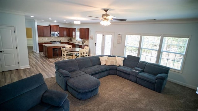 living room with ceiling fan, hardwood / wood-style floors, and ornamental molding