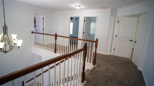 hall featuring dark carpet, a notable chandelier, and ornamental molding