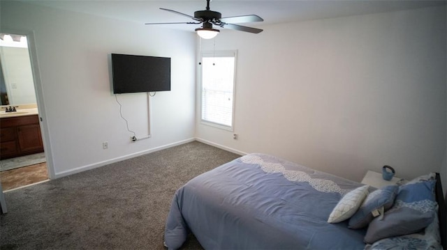 carpeted bedroom with ensuite bath, sink, and ceiling fan