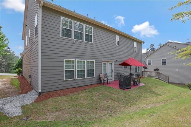 rear view of property featuring a yard and a patio area