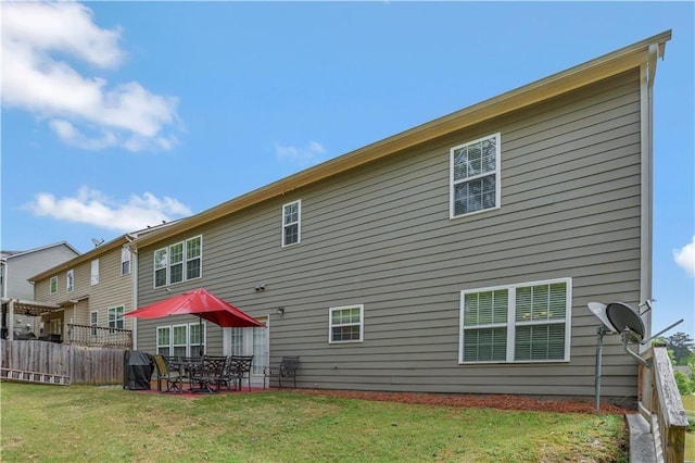 back of house featuring a lawn and a patio