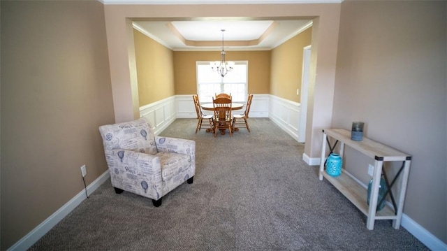 interior space featuring carpet floors, a notable chandelier, a tray ceiling, and ornamental molding