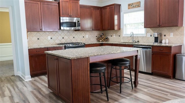 kitchen featuring stainless steel appliances, backsplash, and light hardwood / wood-style flooring