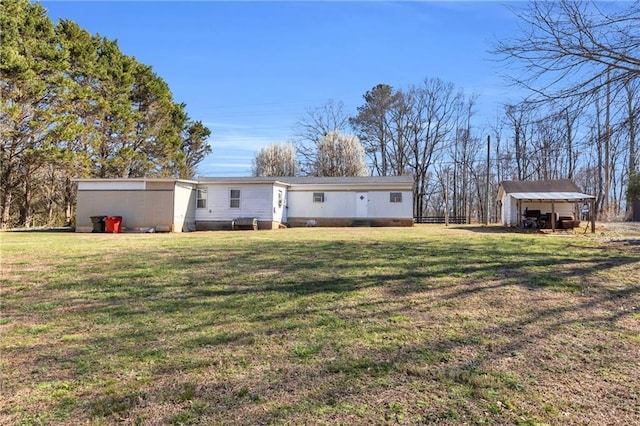 rear view of house with an outbuilding and a lawn