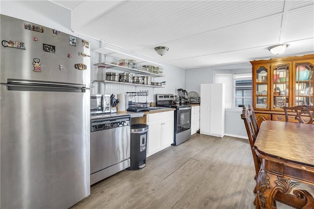 kitchen featuring light wood-style flooring, white cabinets, stainless steel appliances, and open shelves