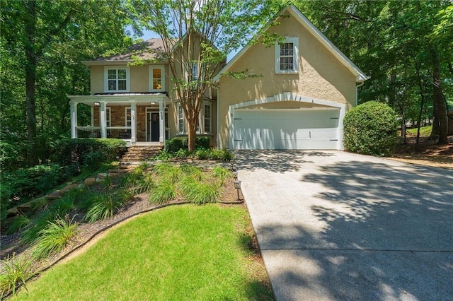 traditional-style house featuring an attached garage, covered porch, concrete driveway, and stucco siding