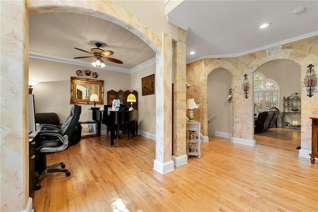 office with light wood-style flooring, arched walkways, a ceiling fan, and ornamental molding