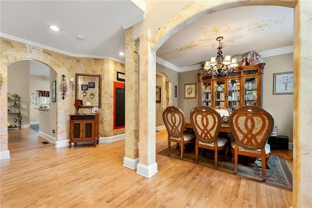 interior space with ornamental molding, arched walkways, and light wood-style flooring