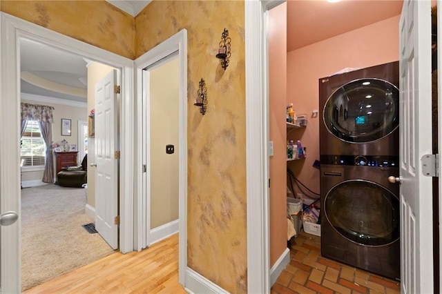 laundry area with laundry area, visible vents, baseboards, and stacked washer / drying machine